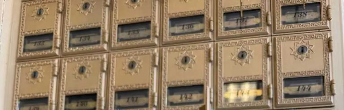 Rows of numbered brass private mailbox doors at The Shipping Place in Magnolia, Texas